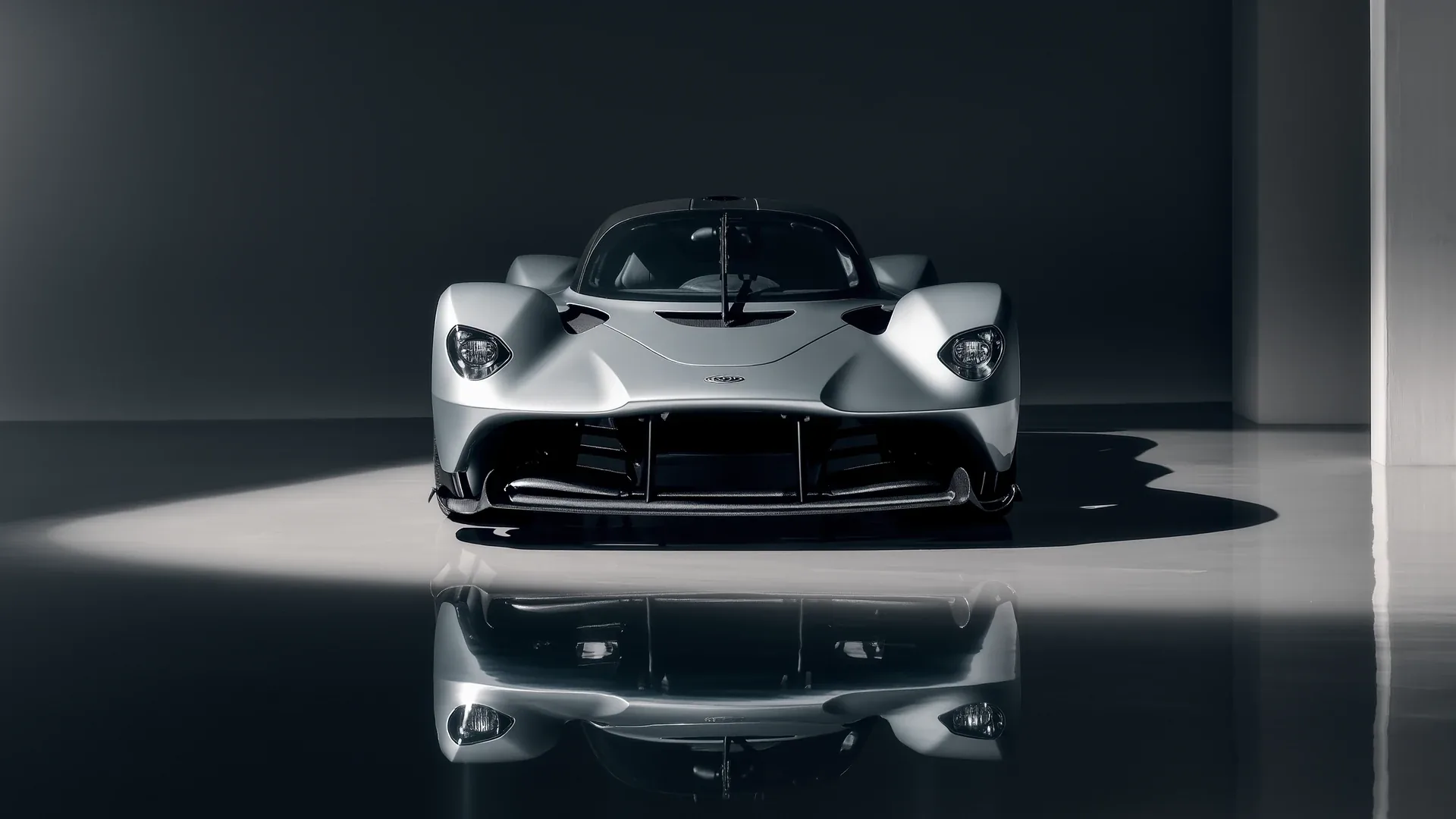 A white hypercar seen head on standing on a mirror finished floor