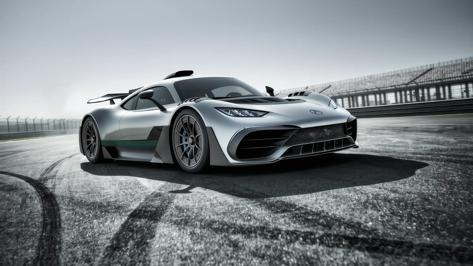 A silver supercar cornering on a race circuit