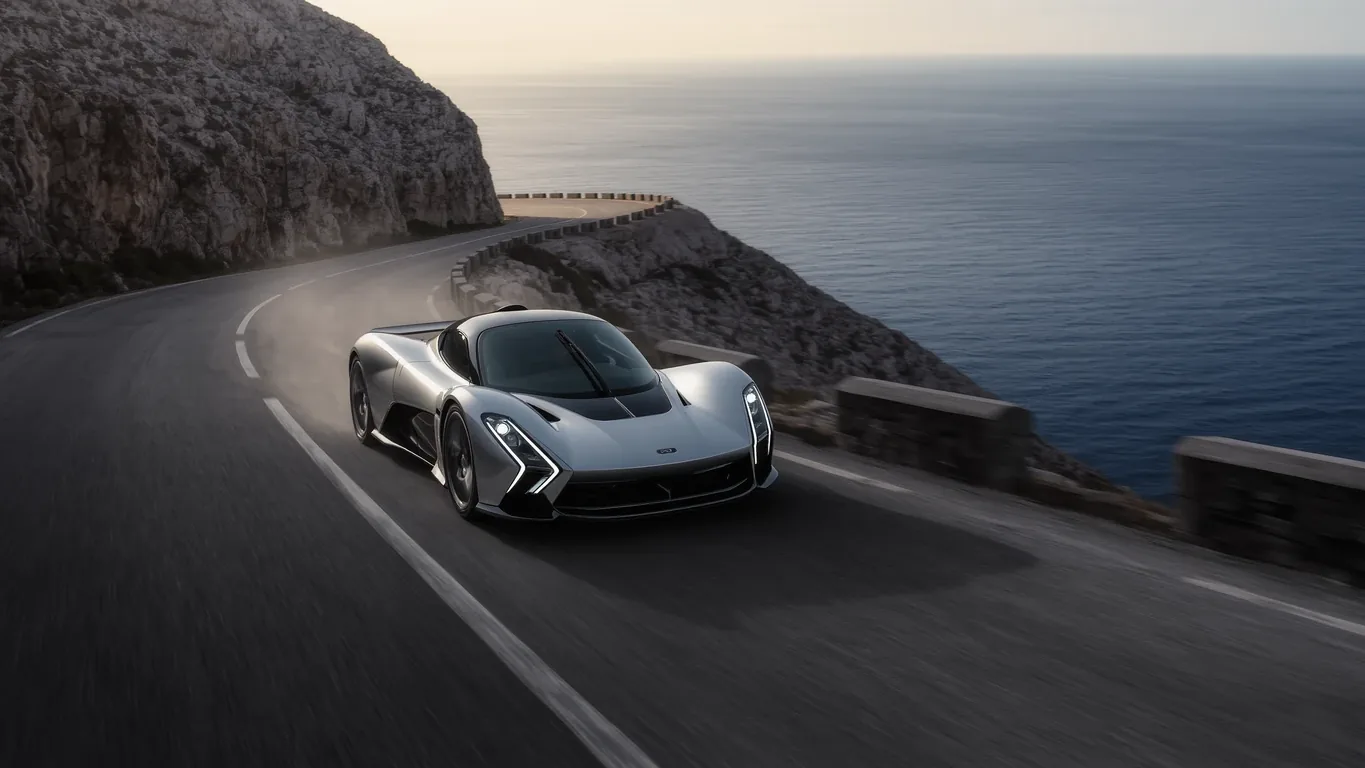 A supercar on a coastal road running along a cliff