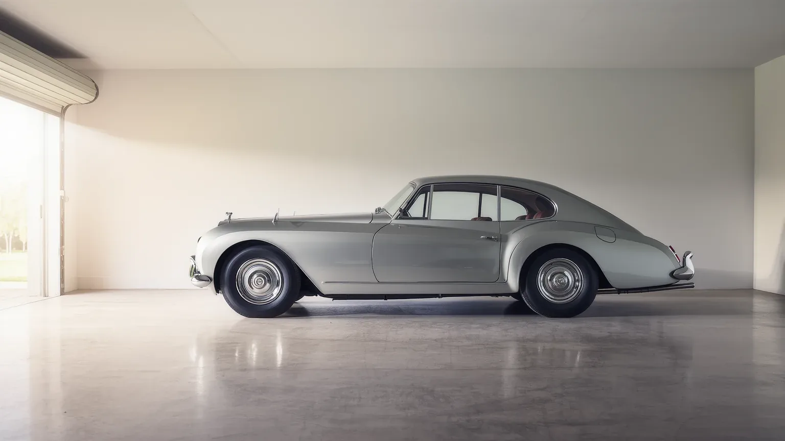 A classic saloon standing alone in a bright empty garage