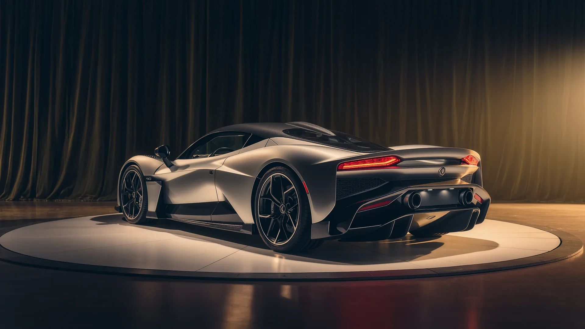 A dark supercar on a turntable under studio lighting